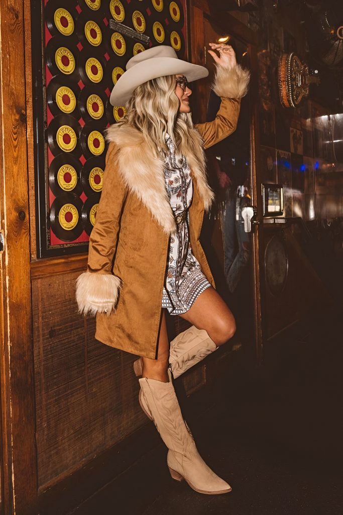 Add a sophisticated twist in western style with a long coat and boots