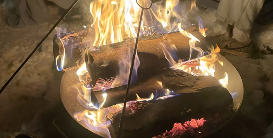 Outdoor bonfire gathering with hot drinks and a good atmosphere
