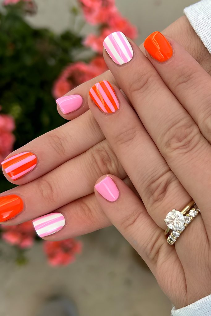 Bright Coral Nails with White Striped Accents