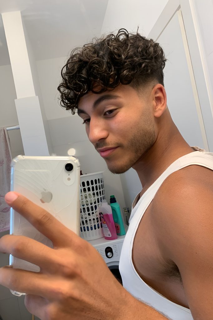 Sharp Drop Fade Accentuating Curly Length on Top
