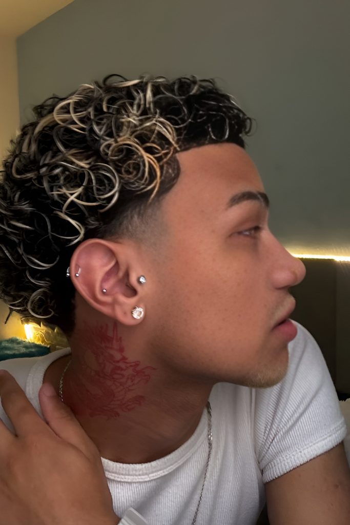 Sharp Fade Highlighting Waves in Loose Curls