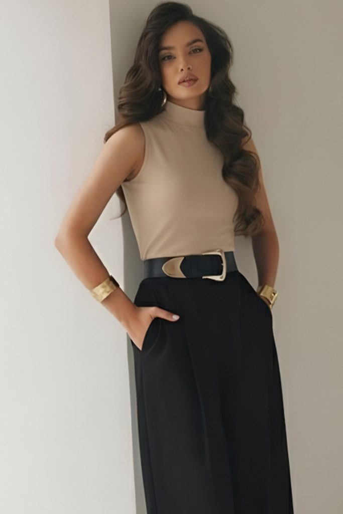 Sleeveless beige knit top with black wide-leg trousers and a belt