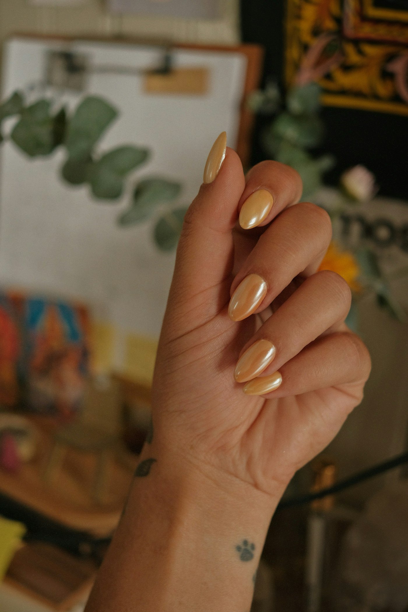 Woman hand with almond shaped golden nails