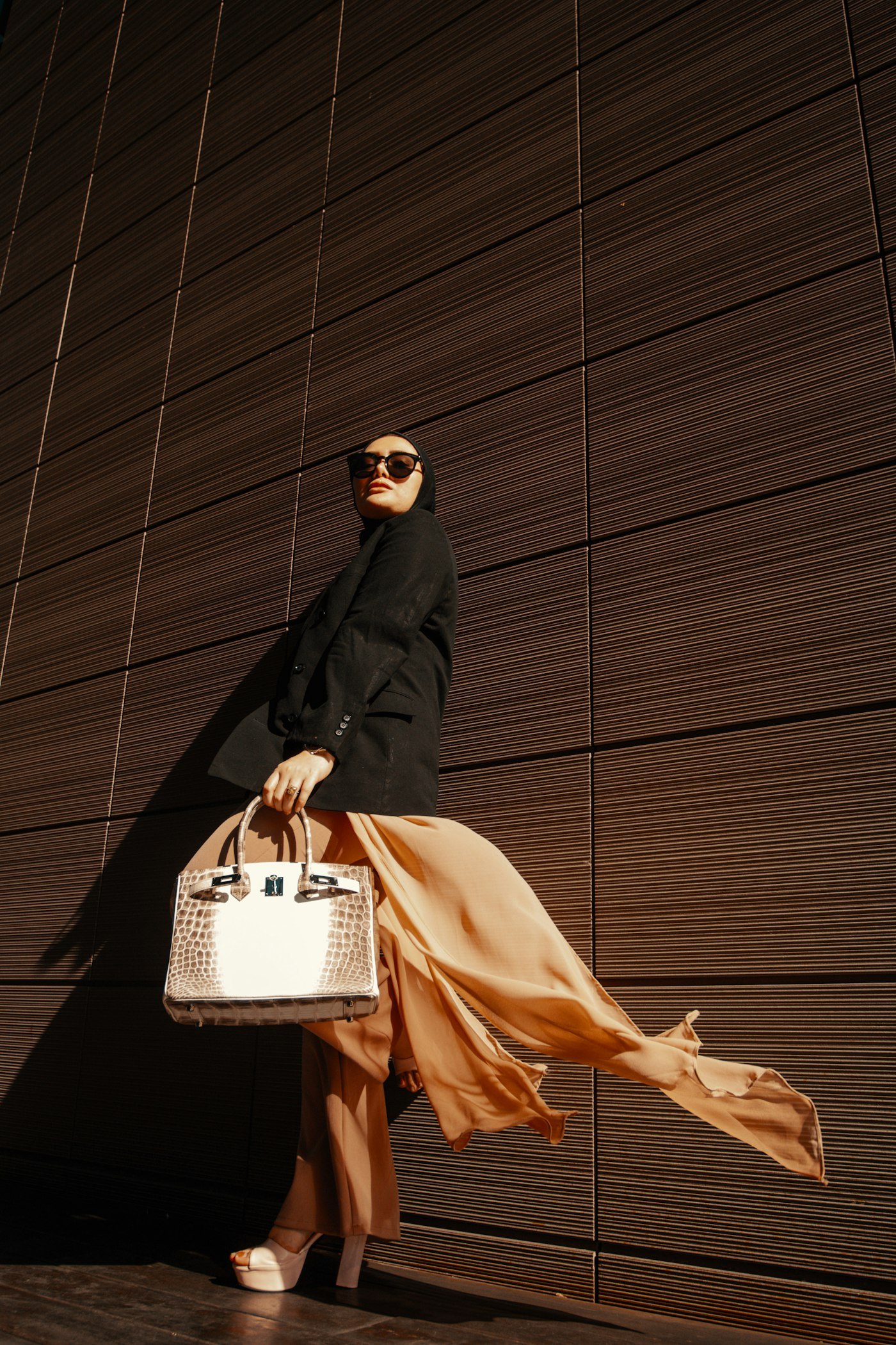 Woman in a black coat carrying a white purse