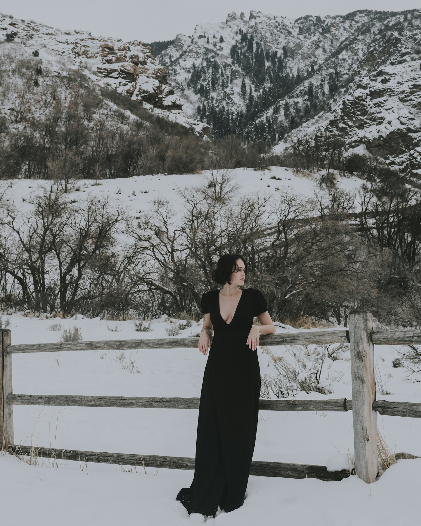 Woman in a black dress standing in the snow, a black dress idea for a winter wedding