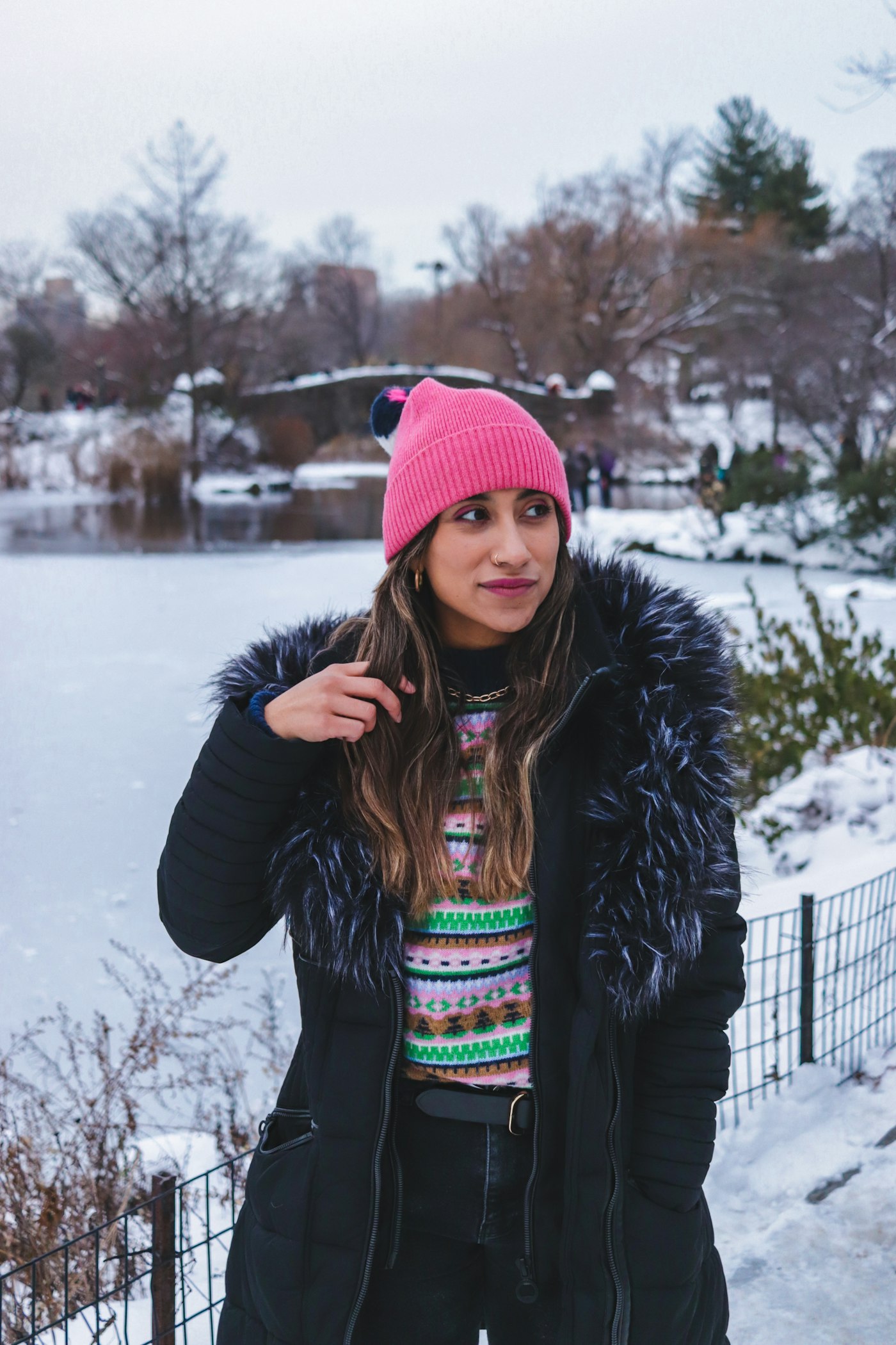 Woman in a black jacket and red knit cap in the snow