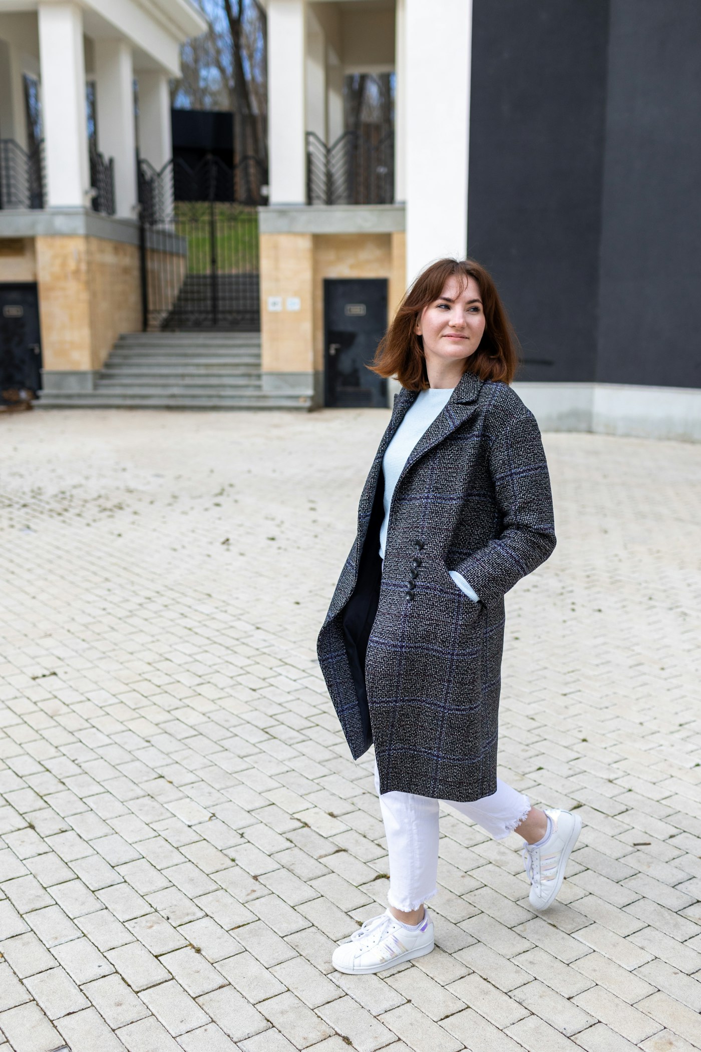 Woman in a blue blazer standing on a sidewalk
