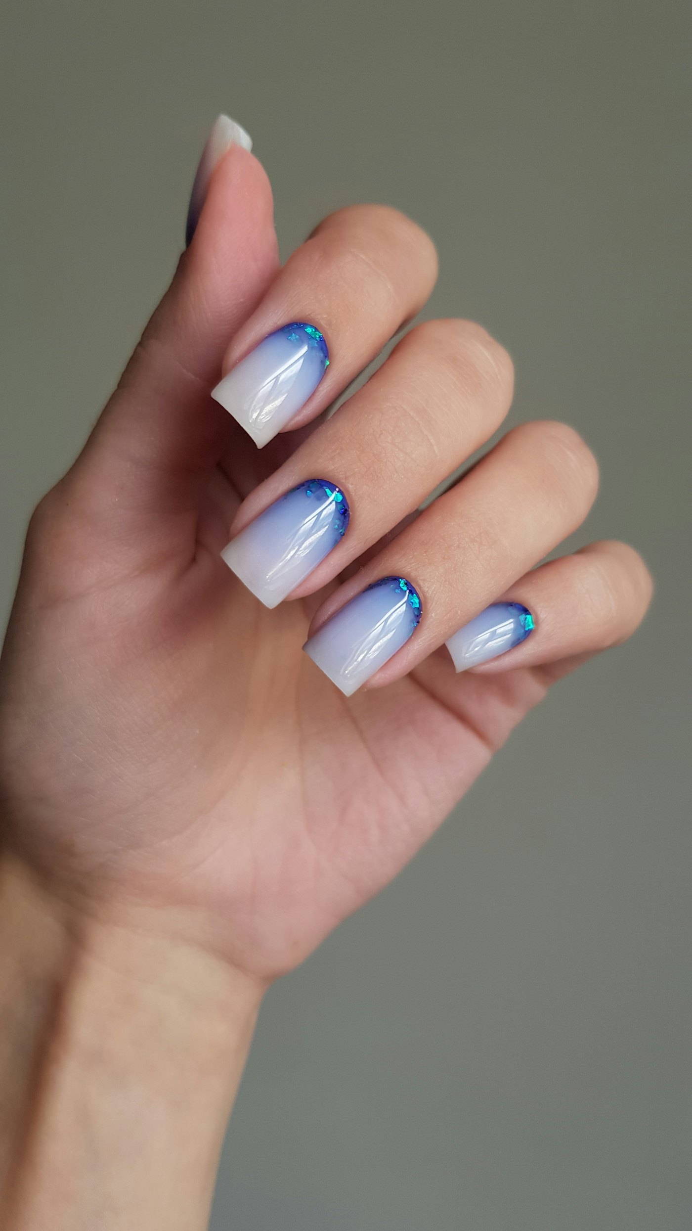 Woman hand with blue and white ombre nails
