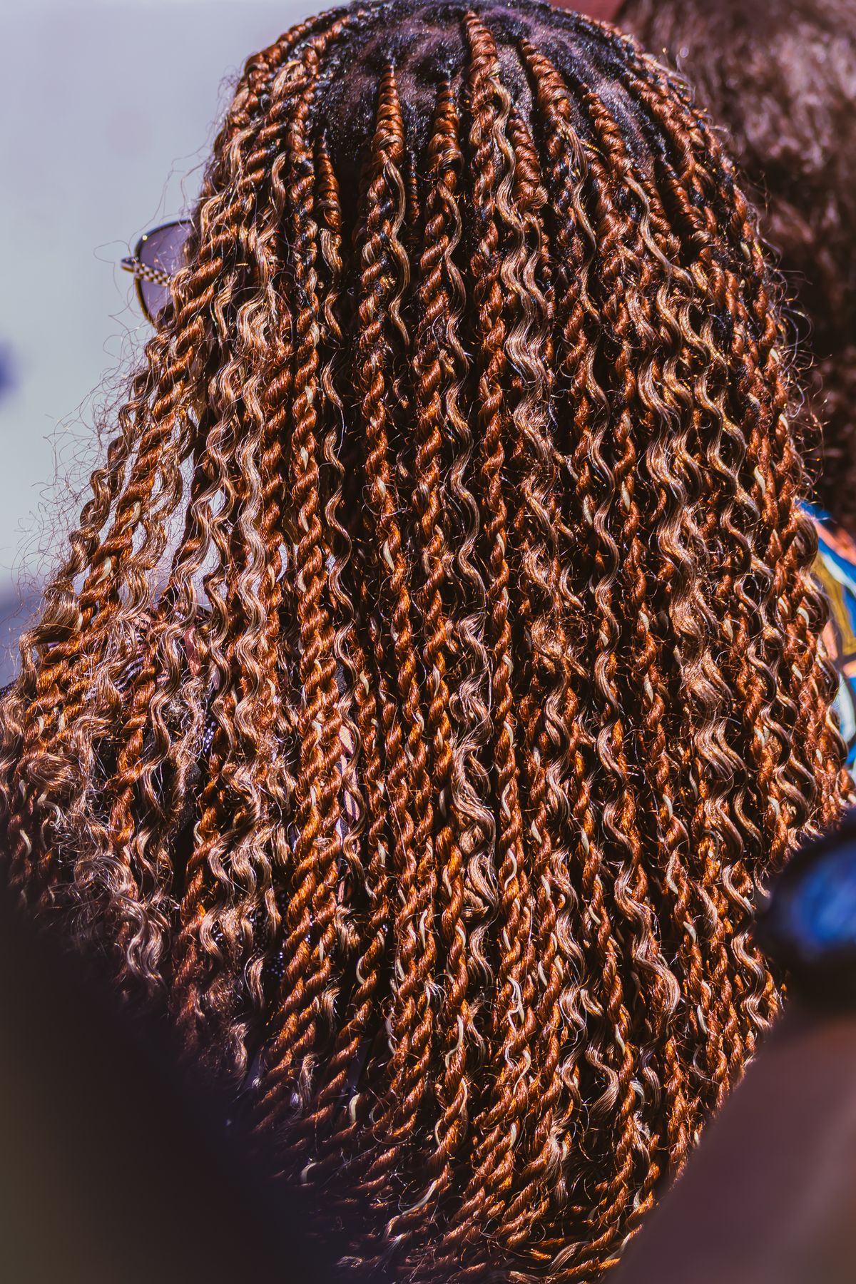 Back view of long copper brown twists with a spiral texture hanging down a woman's back