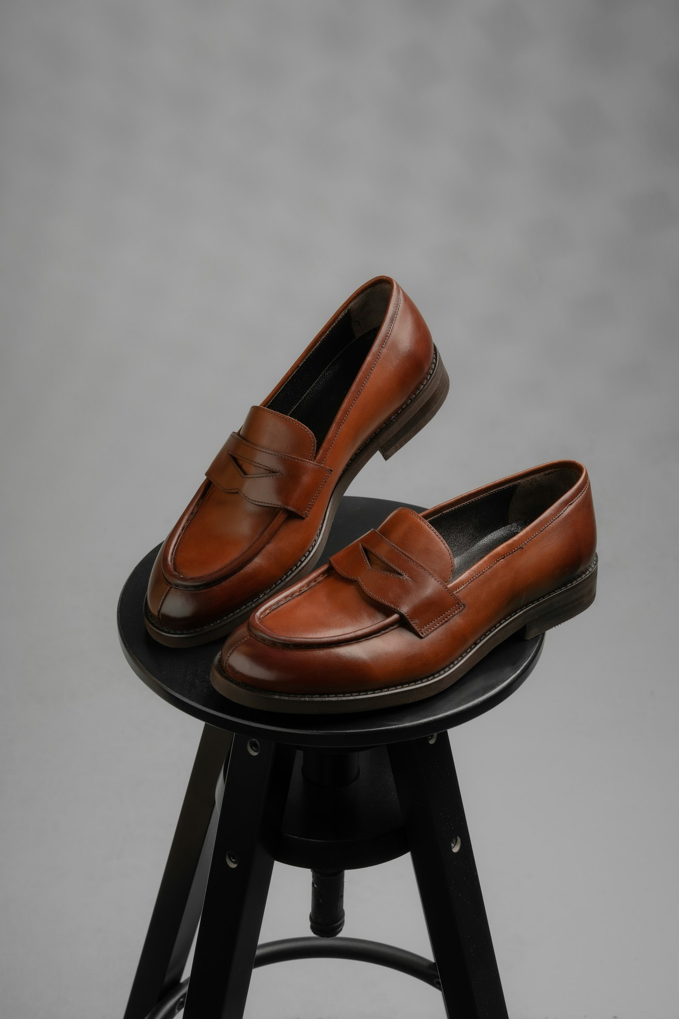 A pair of brown leather loafers on a stool