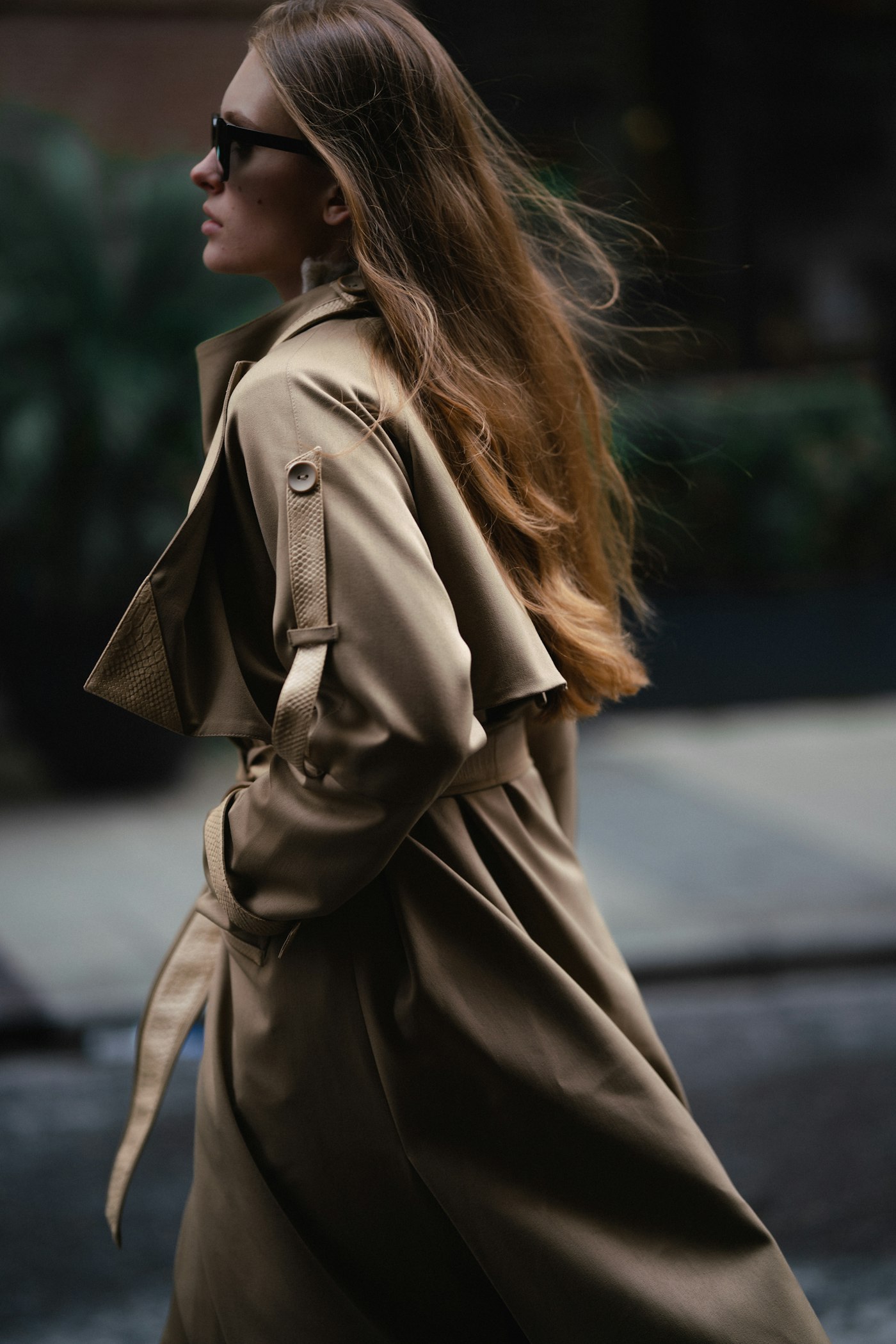 Woman walking down the street in a trench coat