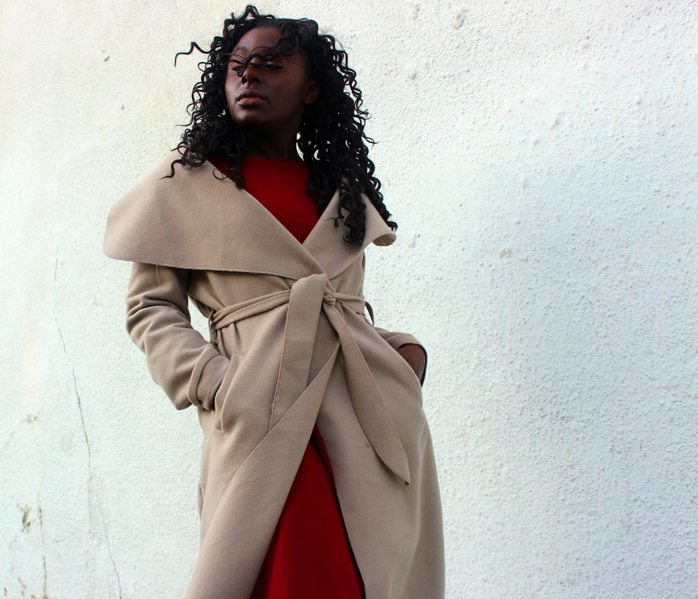 Woman wearing a brown coat with her hands in her pockets
