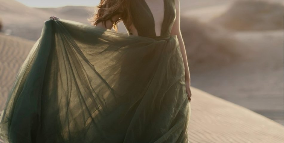 Woman in a green dress standing outdoors as Christmas outfit inspiration