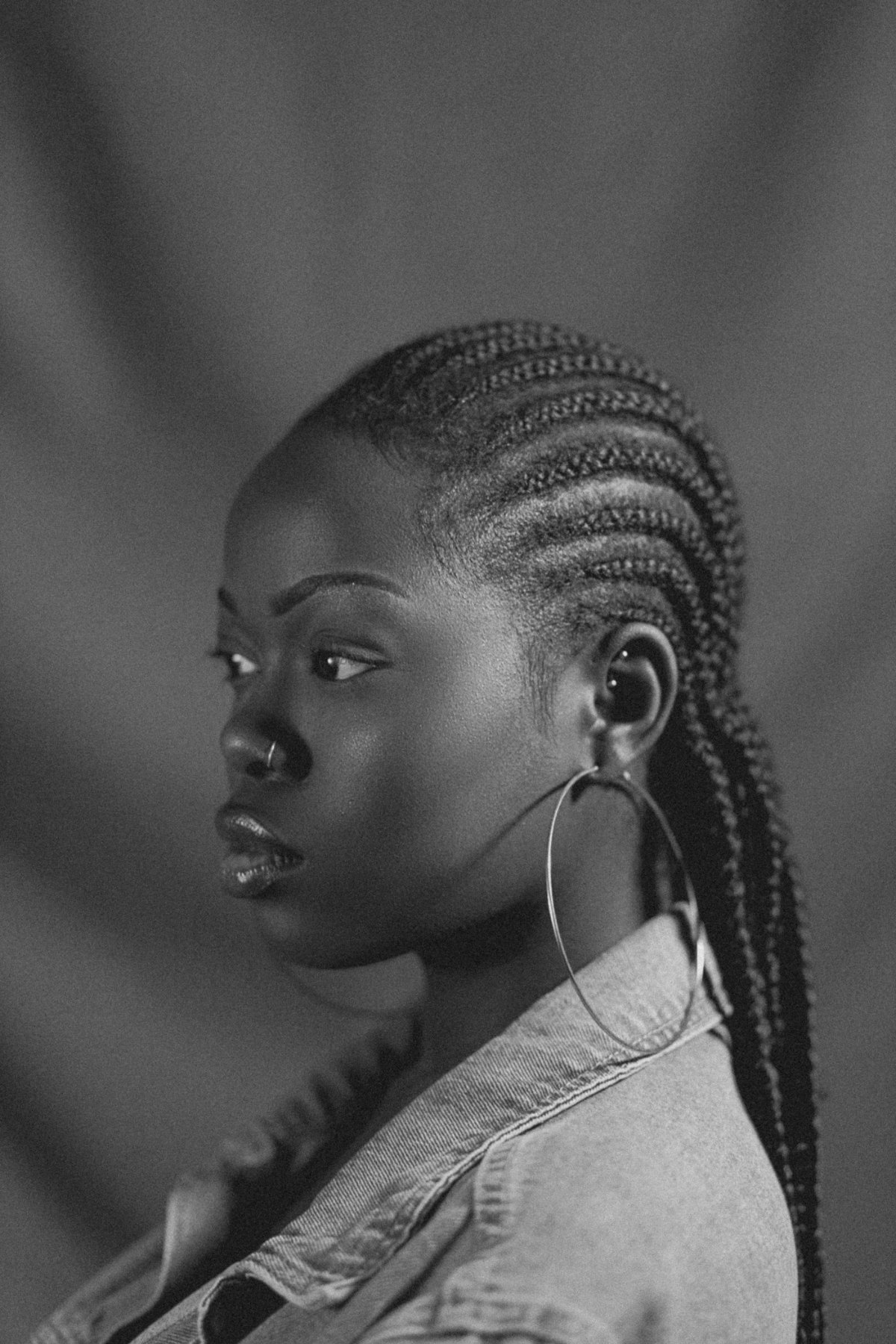 Woman with cornrows and a denim jacket