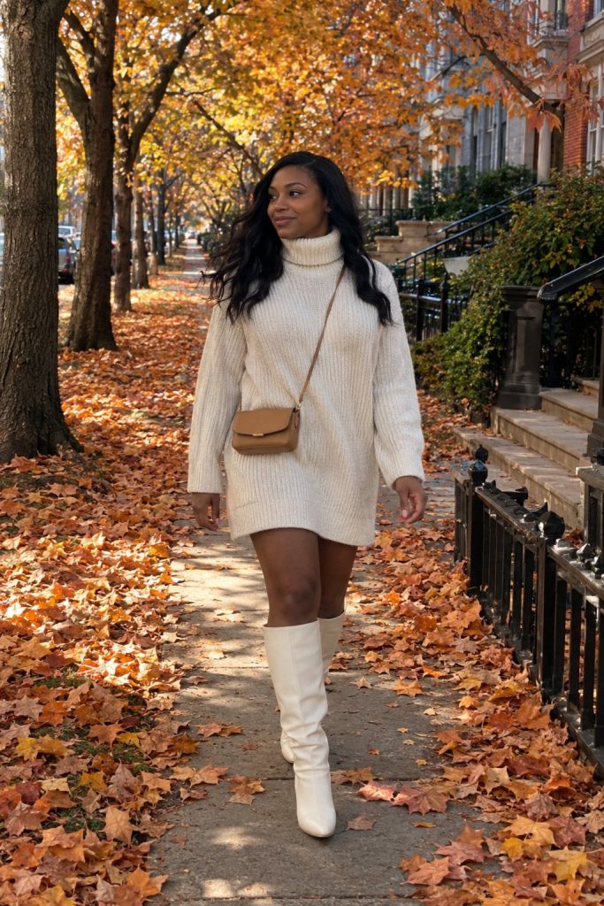 Cream chunky turtleneck sweater dress with white knee high boots and a crossbody bag