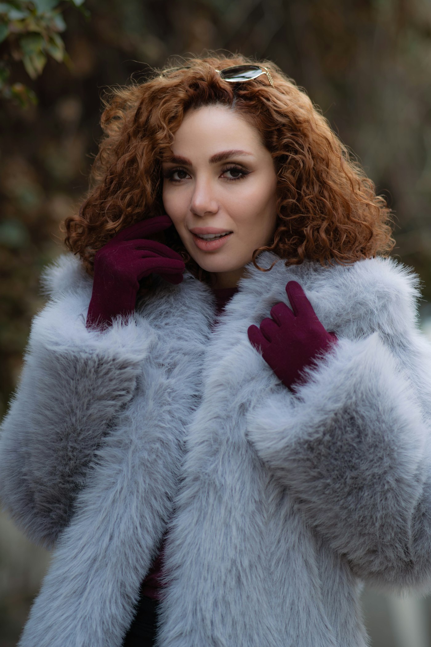 Woman with curly red hair in a grey fur coat