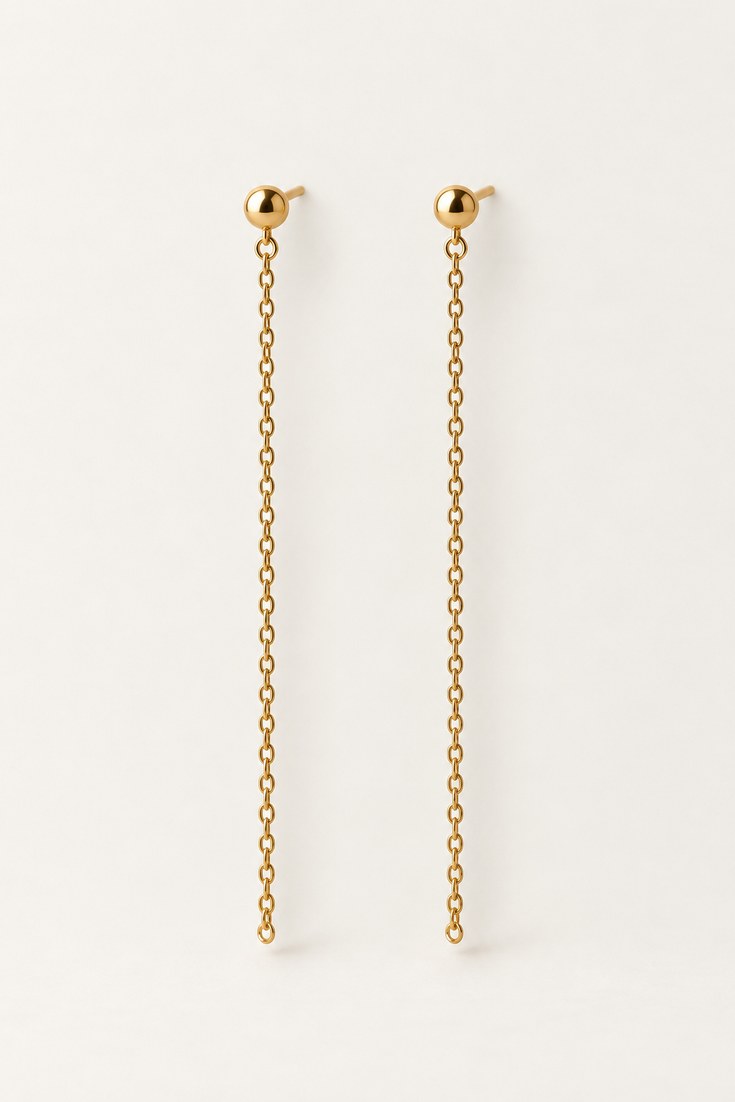 A pair of slim gold linear drop earrings with a straight chain on a soft white backdrop