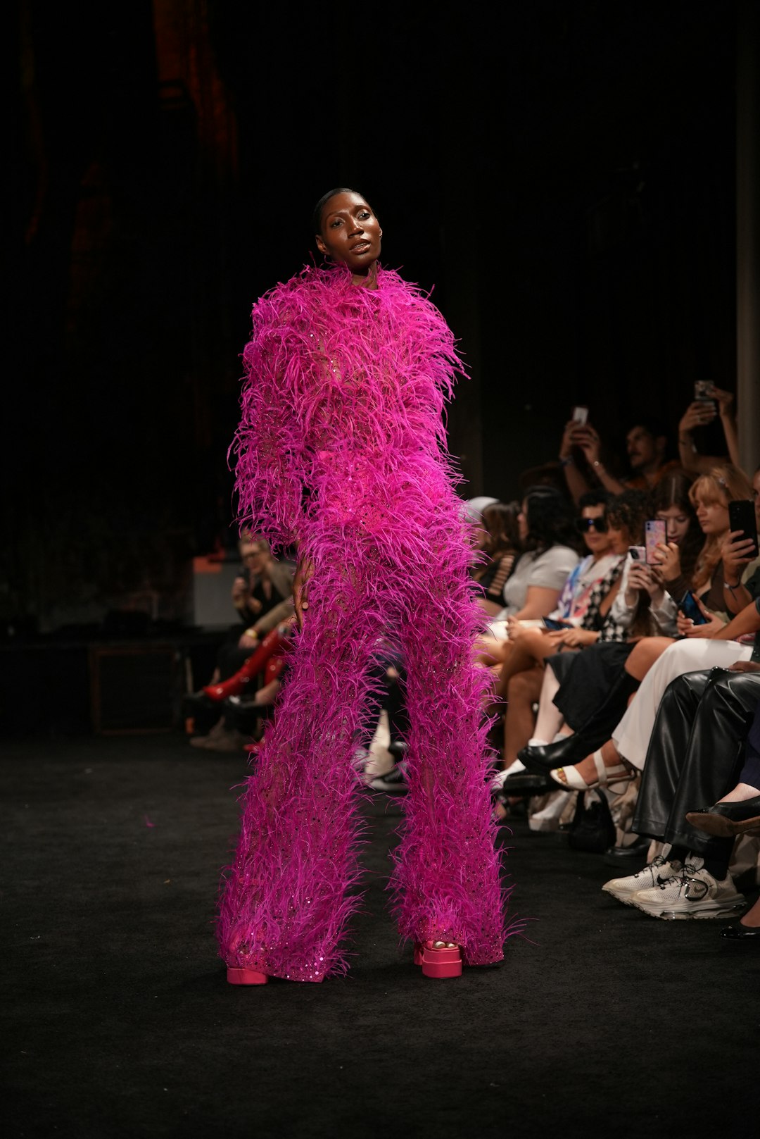 Model in a striking pink feathered outfit