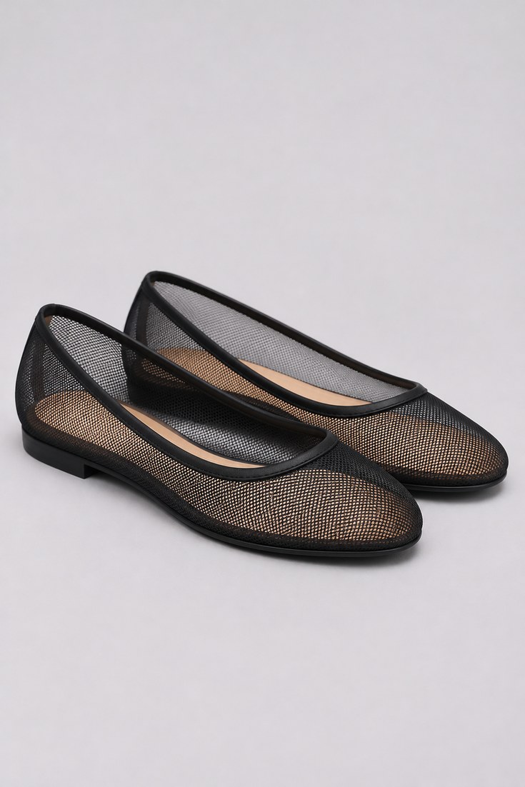 Black mesh ballet flats with a sheer upper on a pale grey background