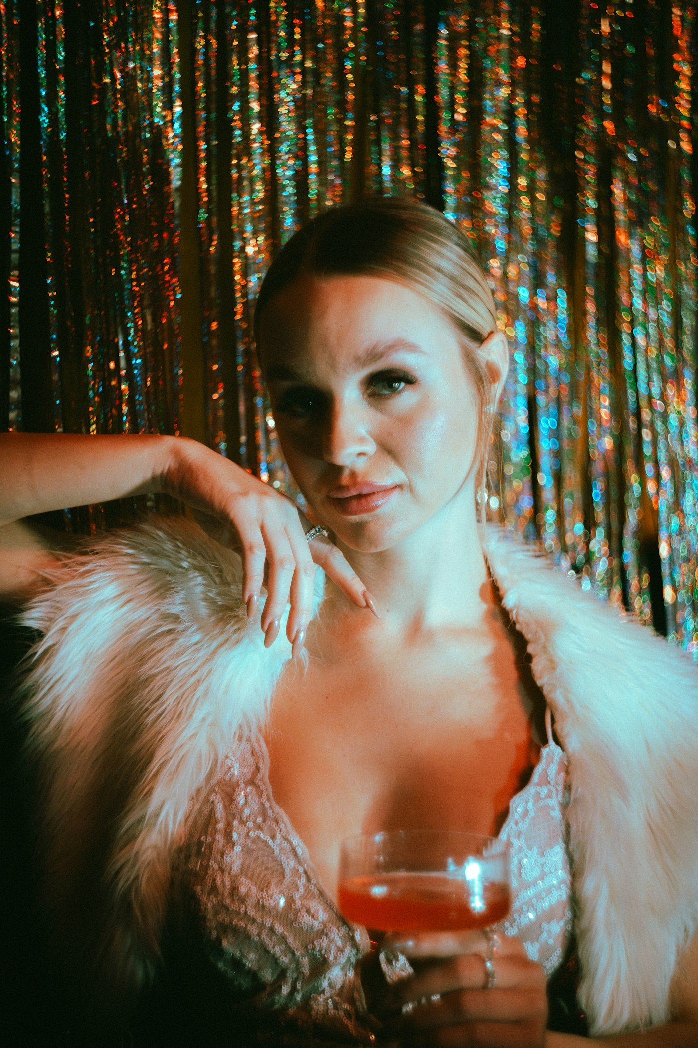 Woman in a fur stole holding a cocktail