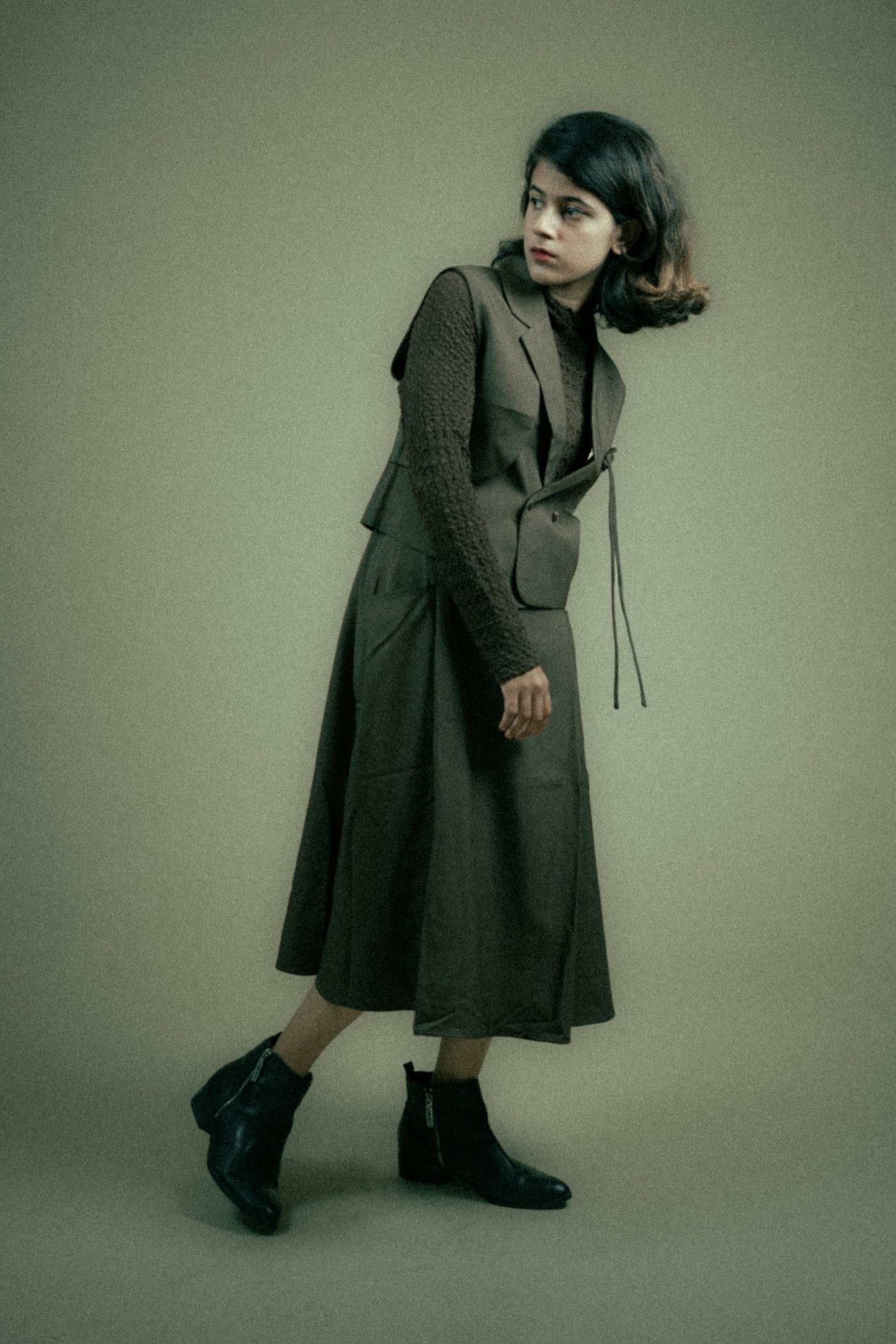 Woman in a gray knit dress and black boots
