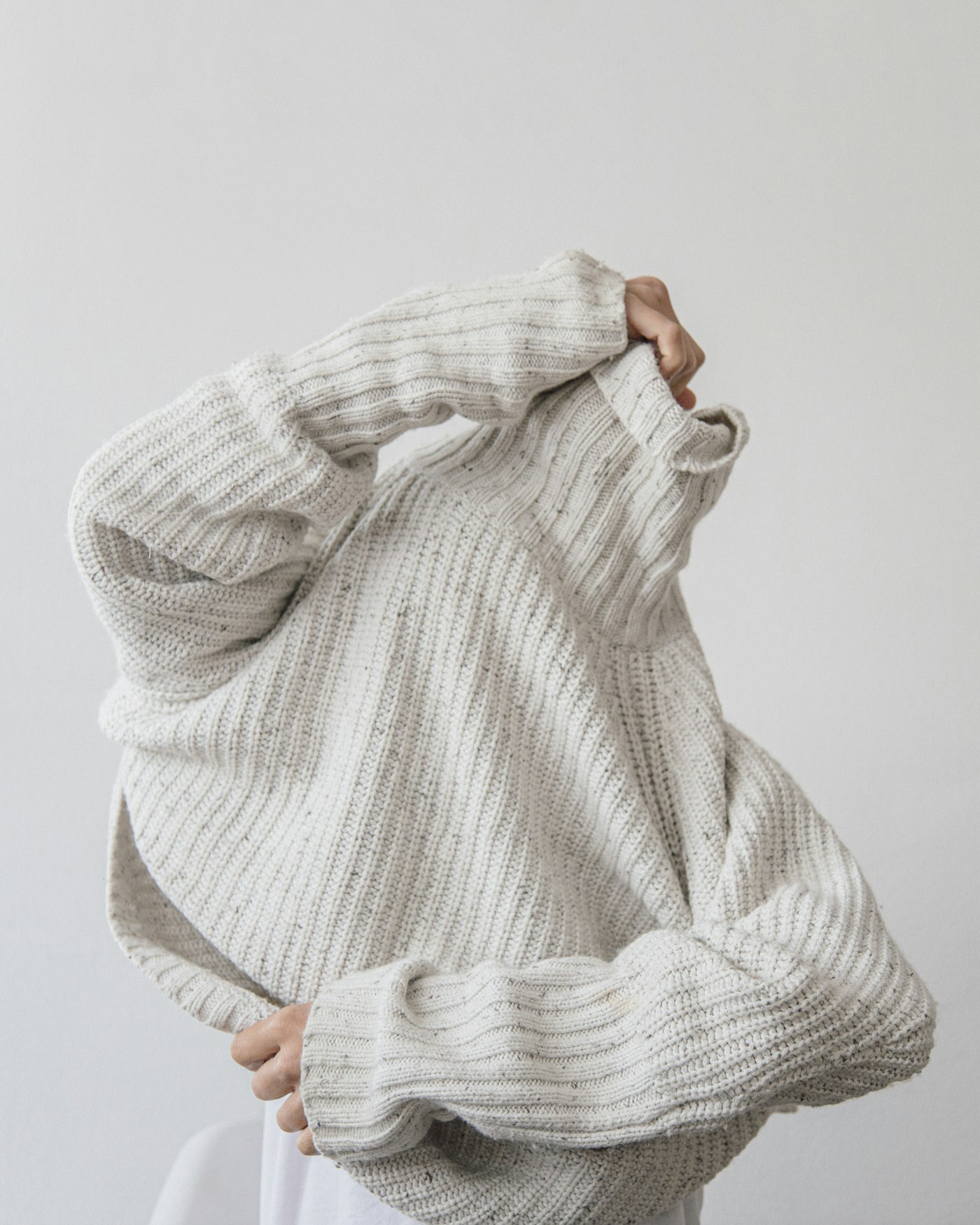 Person wearing a grey knit sweater