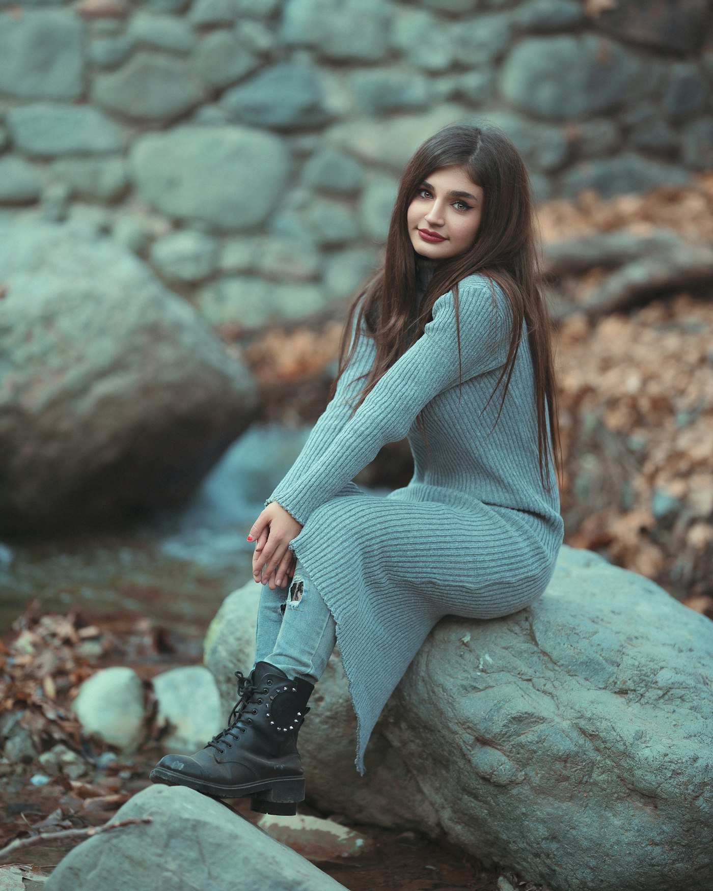 Woman in a grey ribbed sweater dress layered over jeans