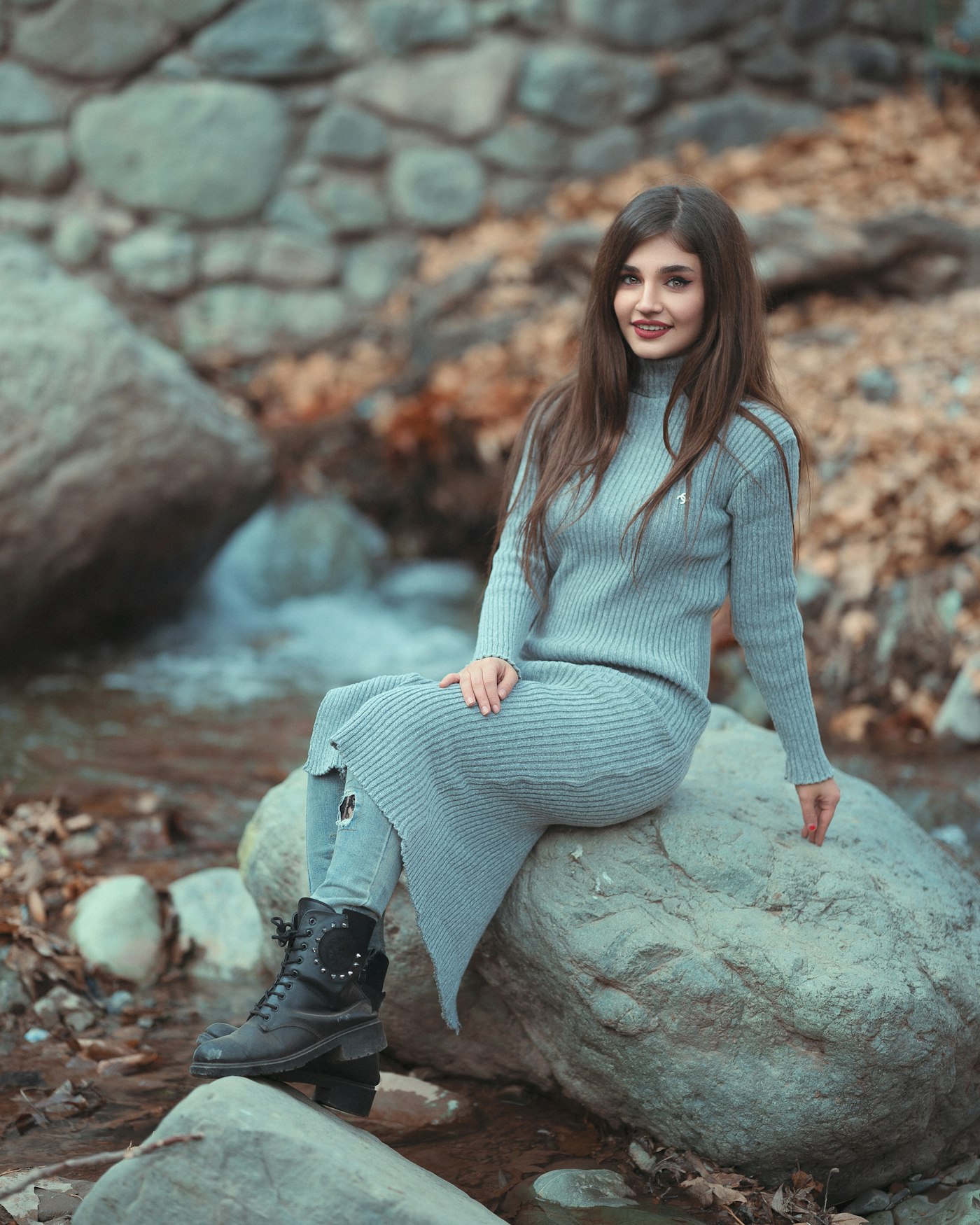 Woman in a grey sweater dress and black boots