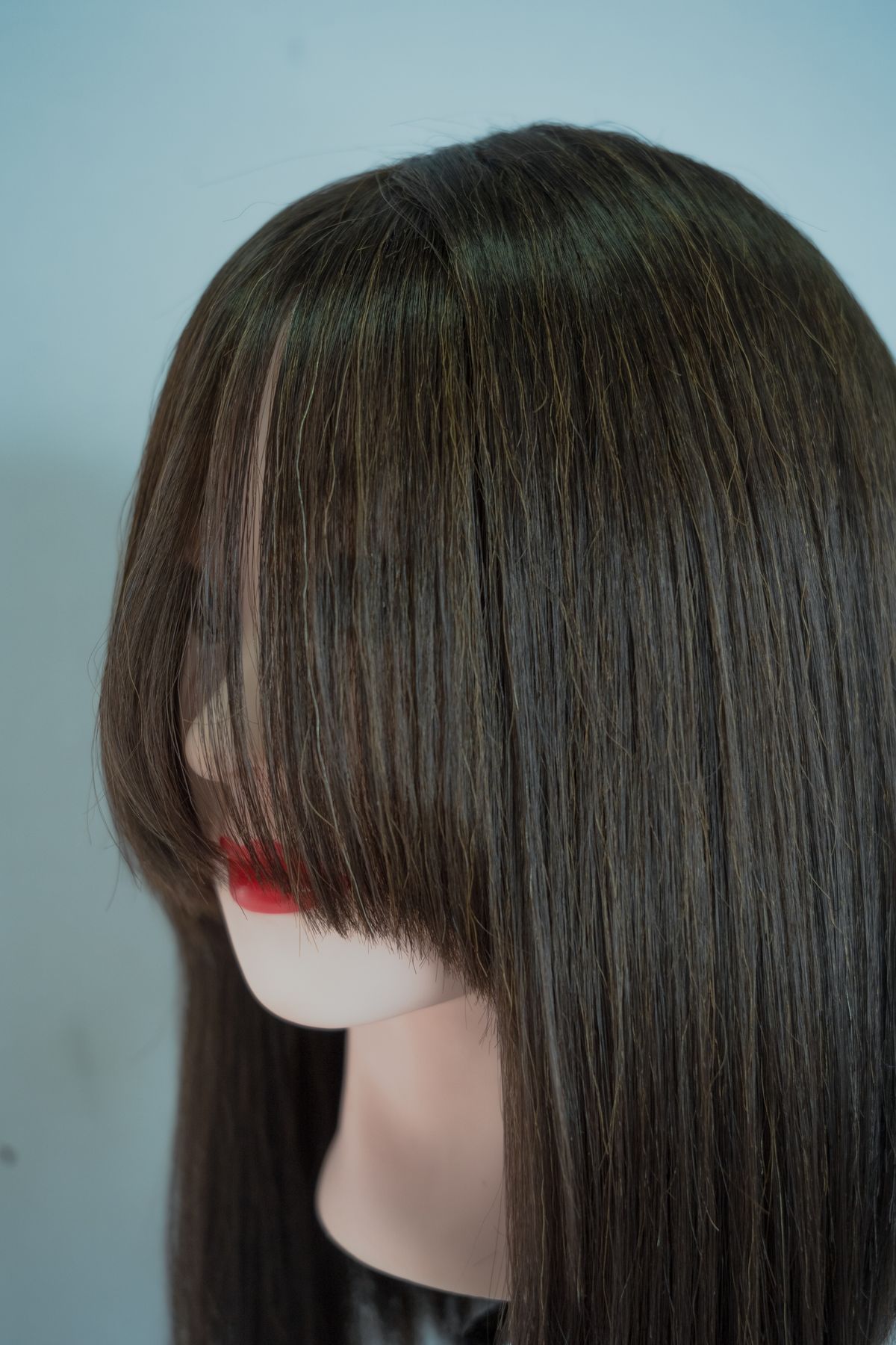 Close-up of sleek, glossy dark brown hair ending in a clean blunt edge