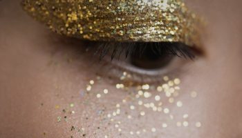 Woman with gold glitter on her eyes as holiday makeup inspiration