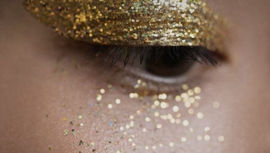Woman with gold glitter on her eyes as holiday makeup inspiration