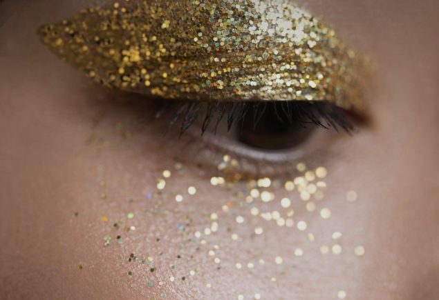 Woman with gold glitter on her eyes as holiday makeup inspiration