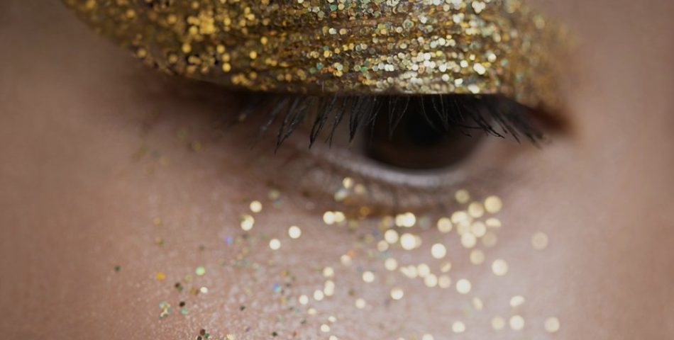 Woman with gold glitter on her eyes as holiday makeup inspiration
