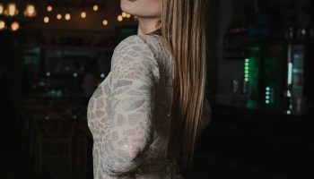 Woman in a sequined dress in a dimly lit bar, holiday party outfit idea
