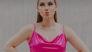 Woman in a pink dress standing with hands on hips