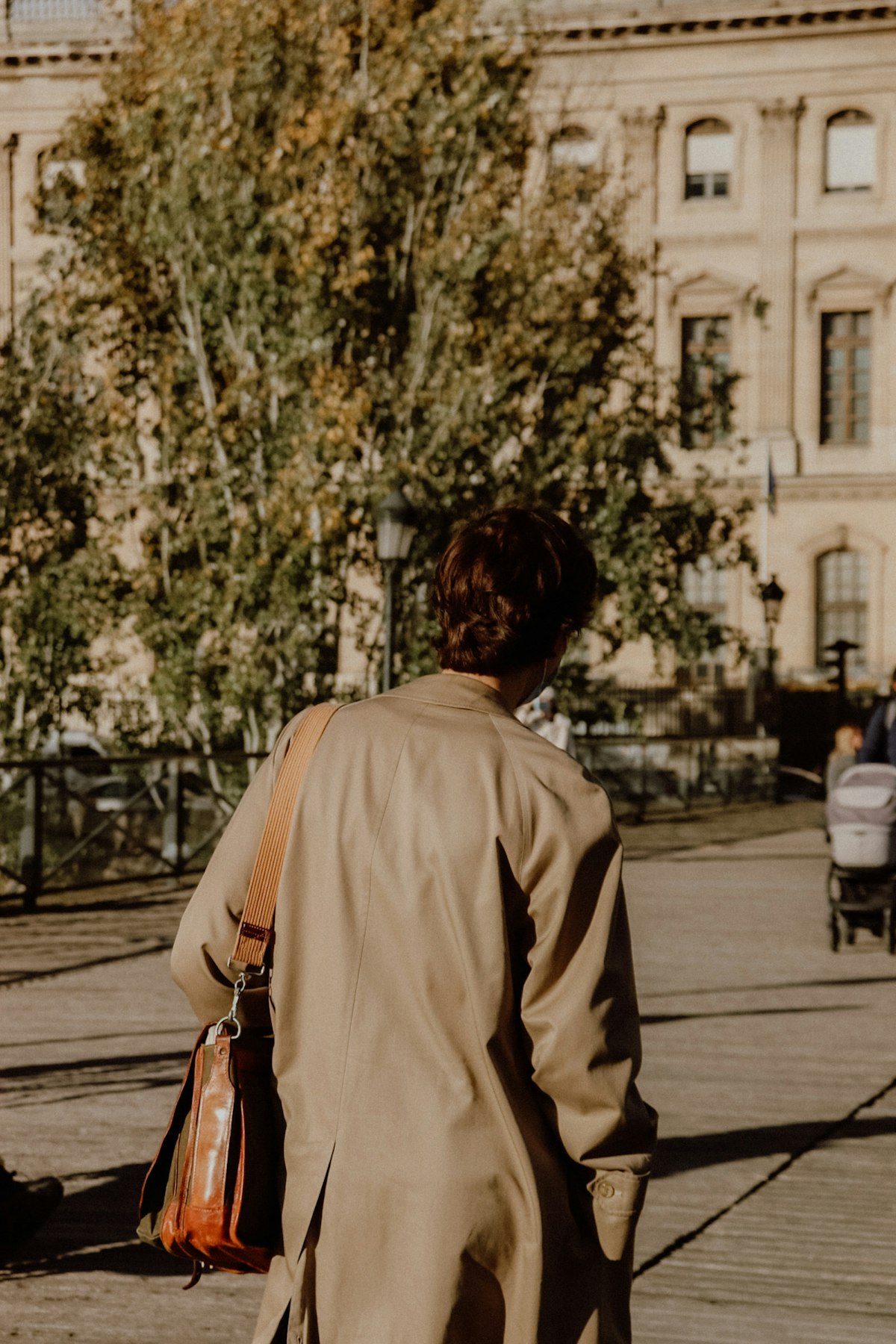 Woman in a beige neutral outfit walking on a sidewalk