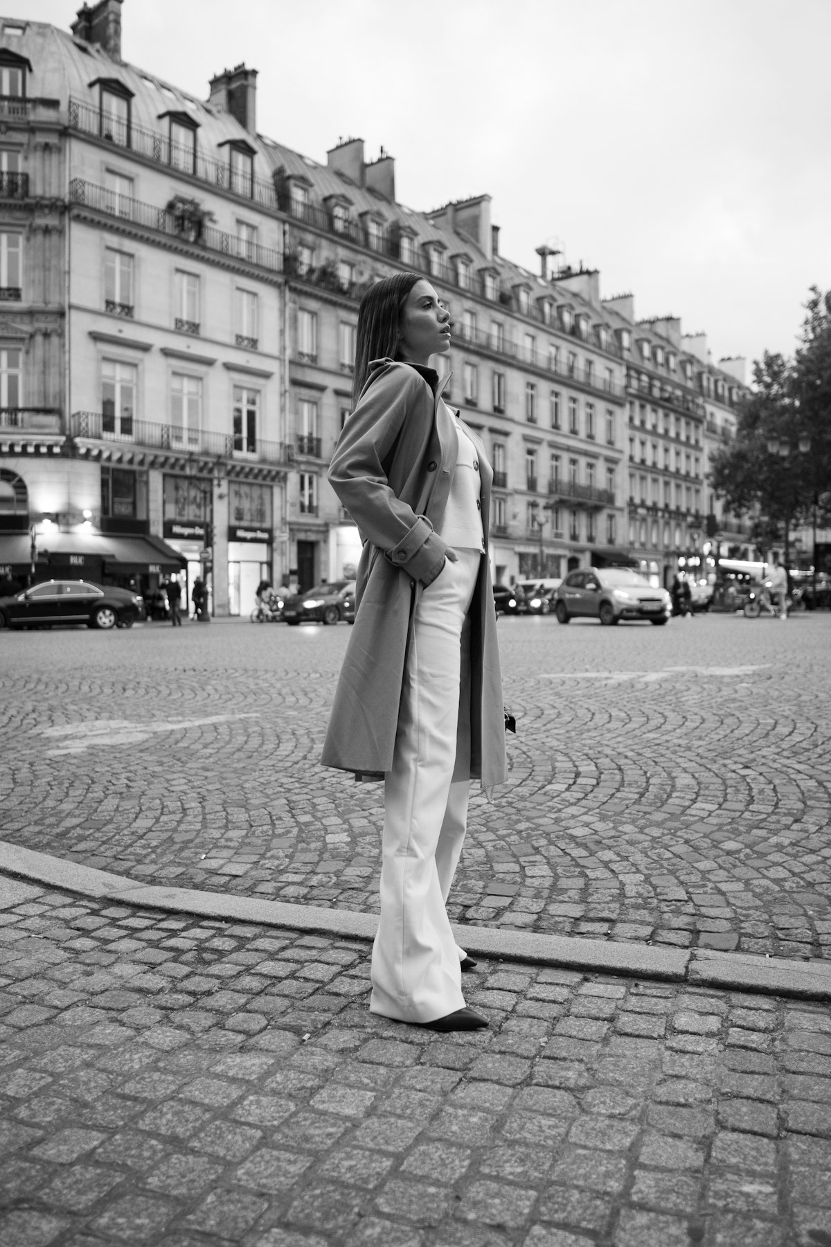 Woman standing on a cobblestone street in an autumn outfit