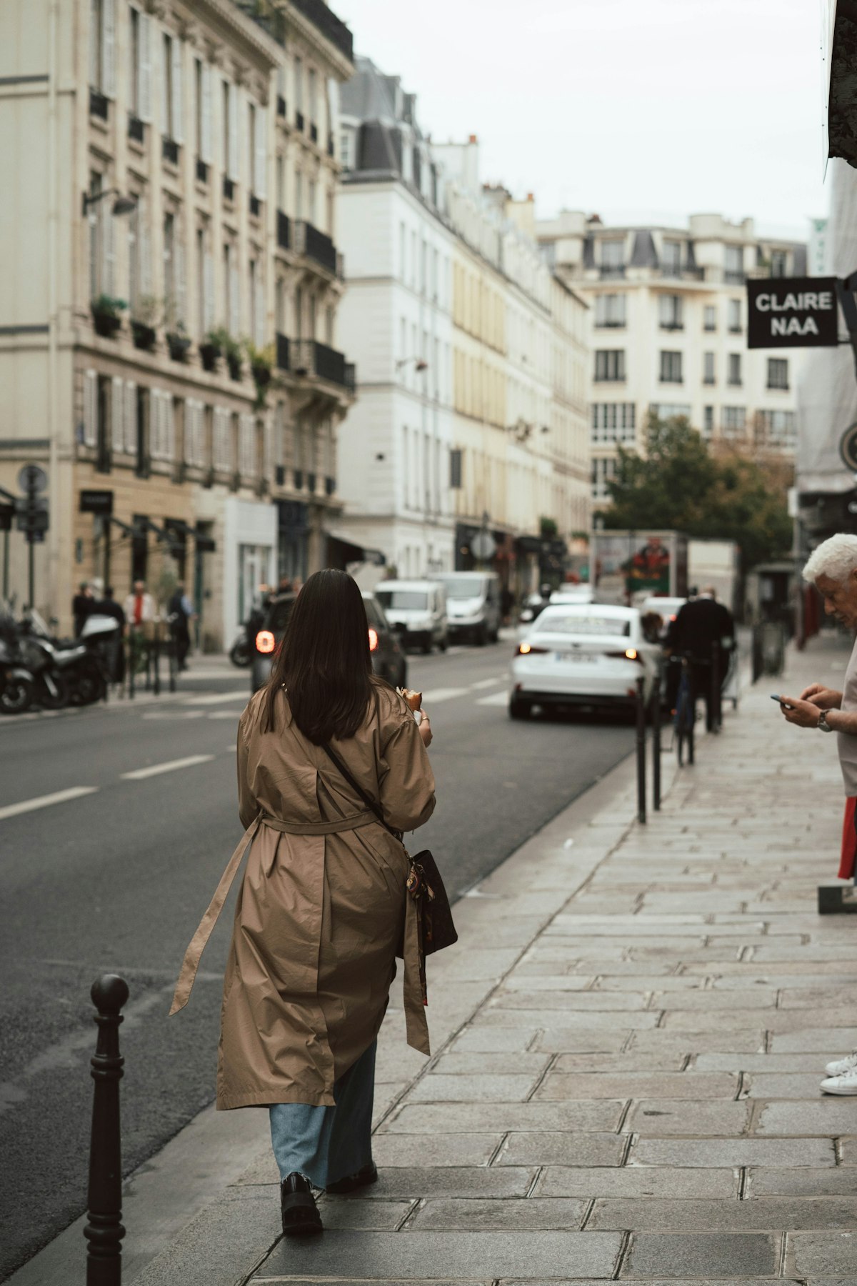 Woman walking down a city street in a long coat