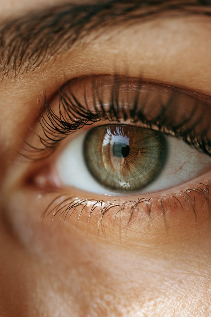 Close-up of a natural eye with dark tinted curled lashes and no mascara