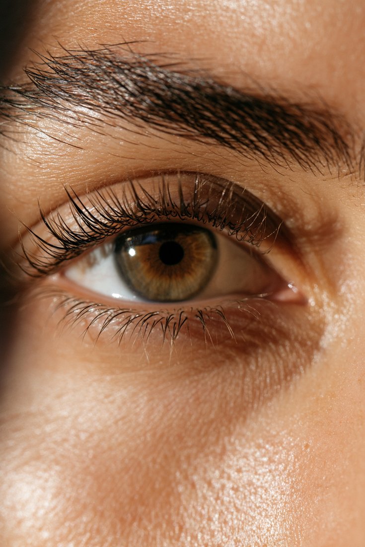 Close-up of a natural eye with lifted tinted lashes and bare skin, no mascara