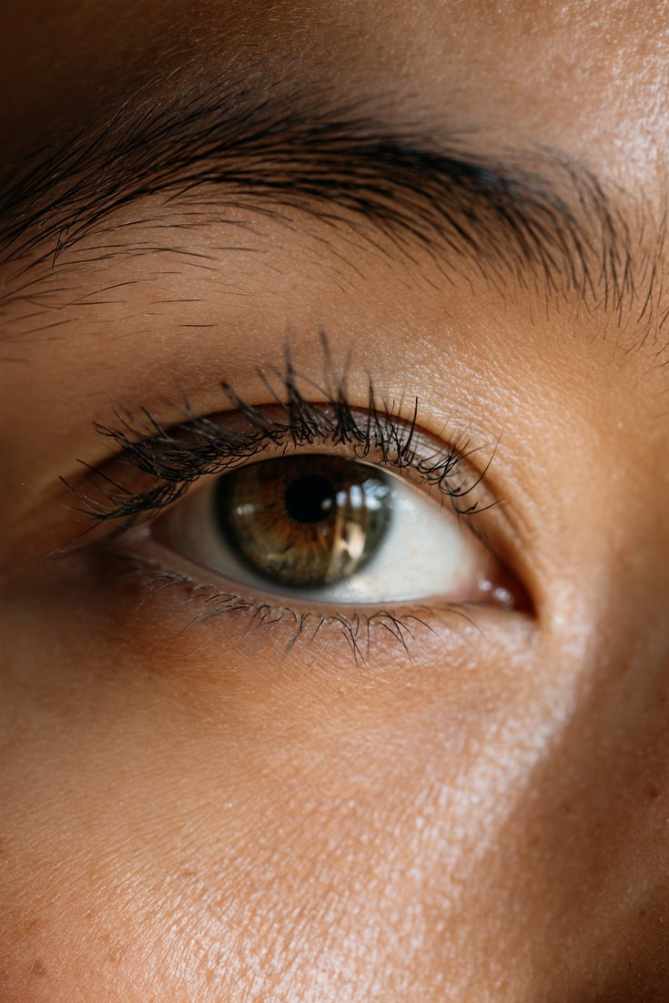 Close-up of a hooded eye with lashes lifted and curled up so they are visible above the lid
