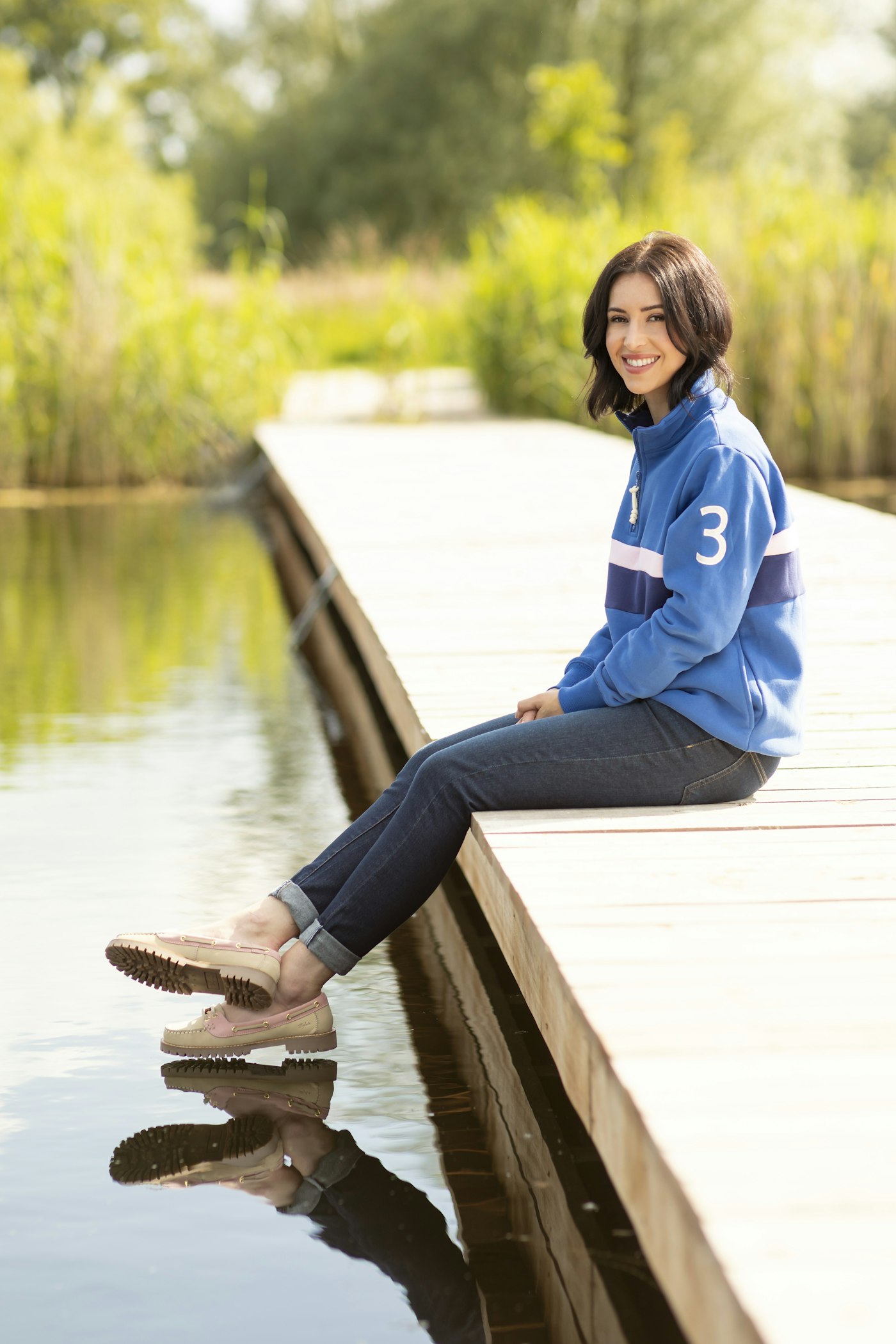 Woman sitting on a dock in a casual outfit