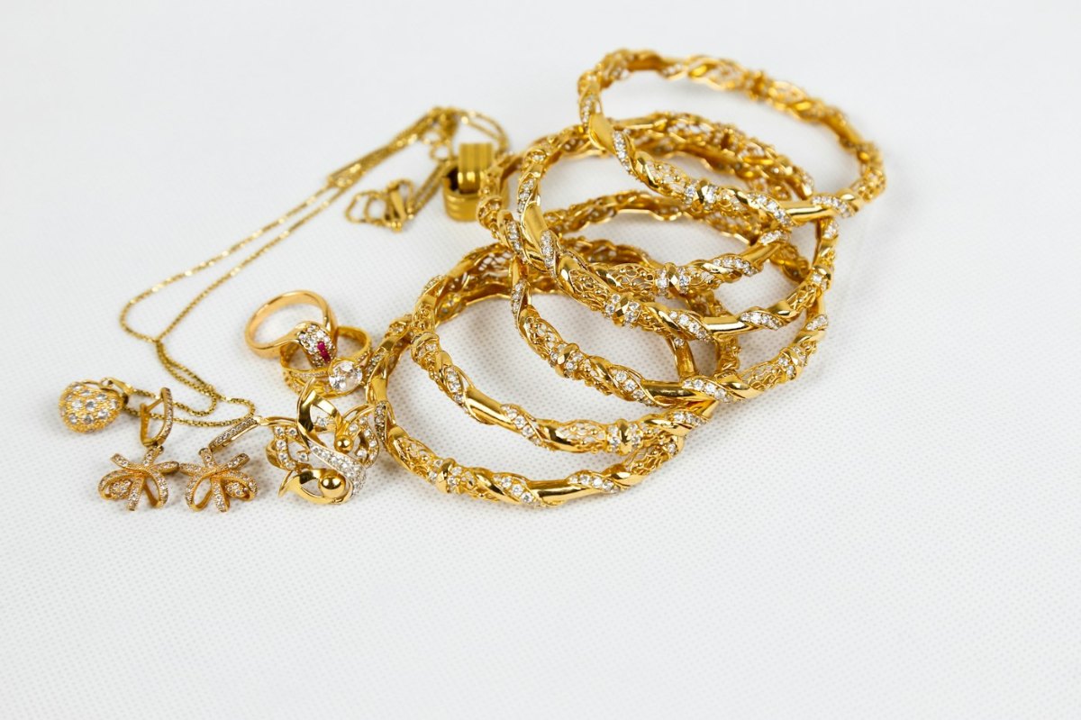 Gold chain necklace laid flat on a white surface