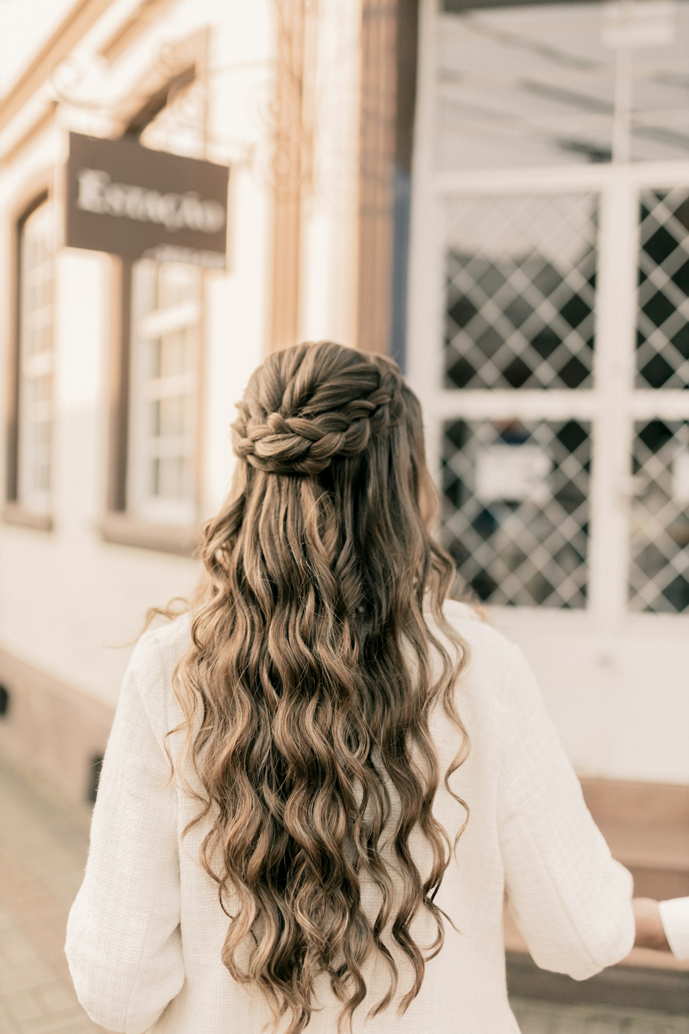 Woman with long hair walking down a street