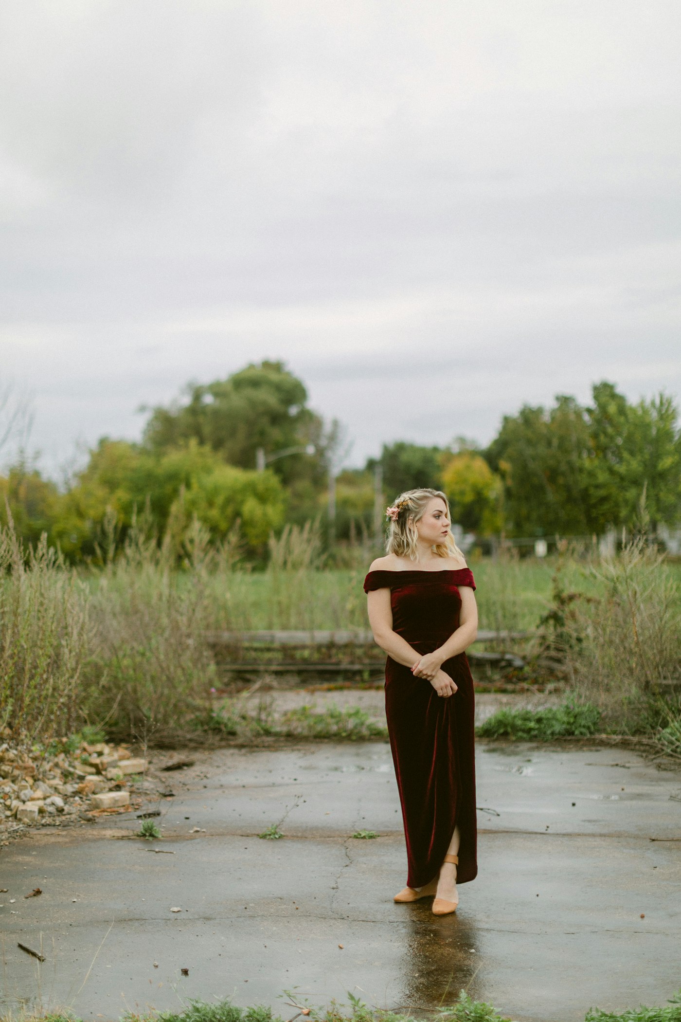 Woman in a maroon dress standing outdoors, a burgundy winter wedding guest idea