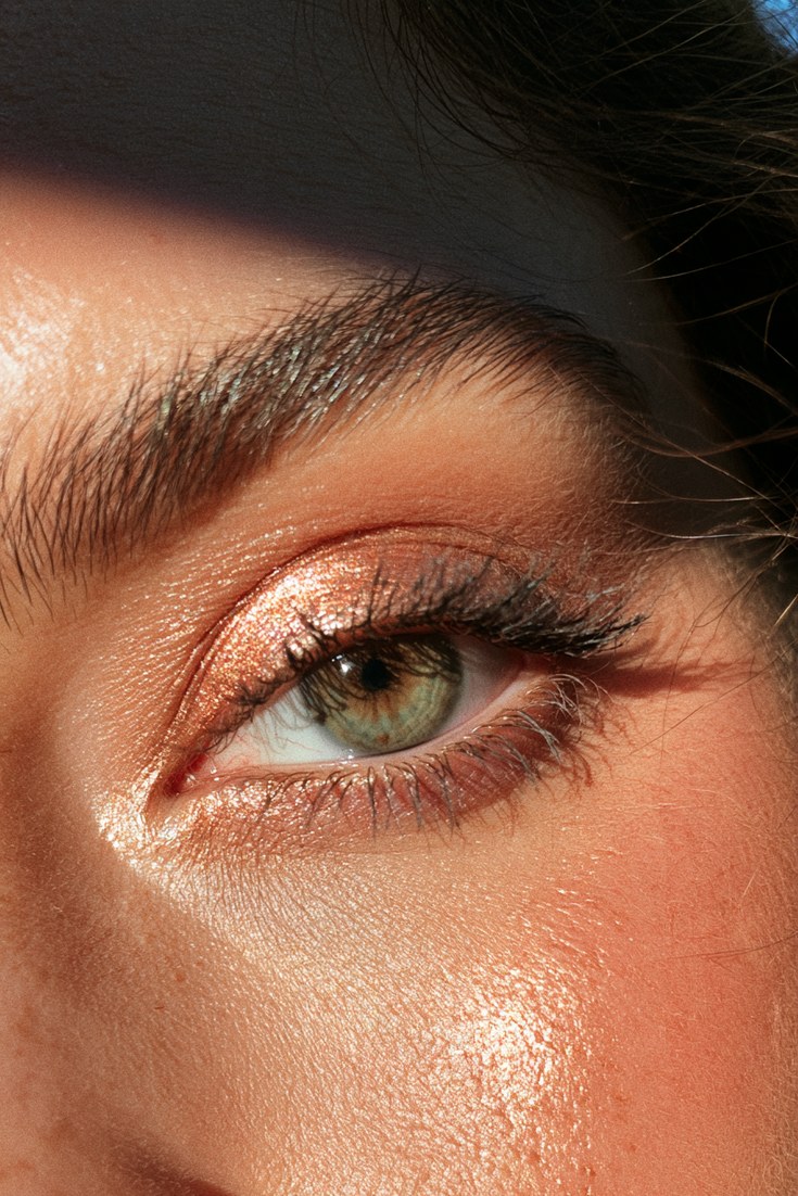 Close-up of an eye with copper shimmer eyeshadow and coppery blush