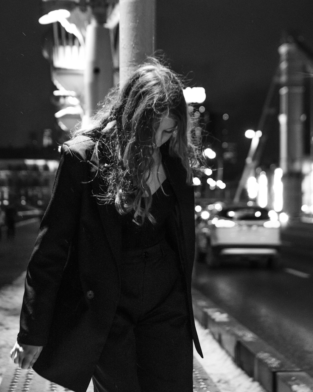 Woman walking down a city street at night