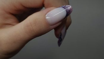 Woman hand with a French manicure and glitter accents