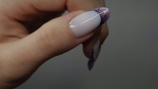 Woman hand with a French manicure and glitter accents
