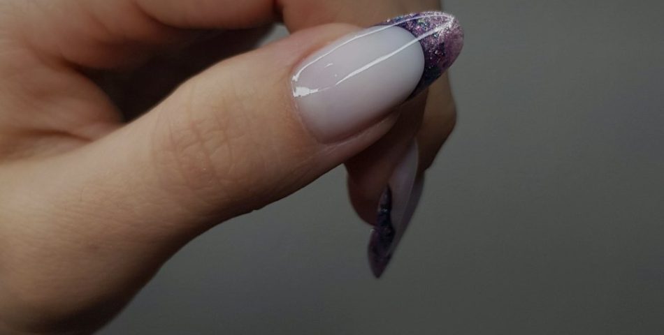 Woman hand with a French manicure and glitter accents